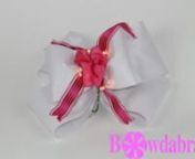 www.bowdabra.comnwww.bowdabrablog.comnwww.facebook.com/bowdabrannnnNow we&#39;re going to make this cute bow that could be used as a birthday center piece, or a little princess party. Let&#39;s get started.nnI&#39;m going to start by taking my Bowdabra Bow Wire, cutting a piece, folding it in half and laying down into my Bowdabra. I&#39;m just going to tuck the ends underneath so they stay out of the way. Then I&#39;m going to take this piece of, it&#39;s a felt, and it&#39;s glittered, and it makes a really pretty ribbon.