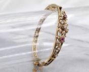 This vintage floral bracelet is in exquisite condition, with a beautiful diamond center, accented by dove grey seed pearls and sparkling rubies. This is a Victorian Revival piece, created in the Retro Era to look like a much older bracelet!nnMetal: 14K Yellow GoldnGem: Diamonds .08 Carats, VS in Clarity, I in ColornGem Measurements: 2.4 mm, RoundnAccents: 2 Ruby, 21 Seed PearlsnWidth: 13.0 mmnInside Circumference: 6 2/3 InchesnMarks: “14K-V” Stamped on the claspnnnFor more information about